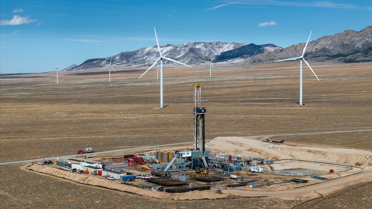 Wind turbines on a mountain ridge above a gas processing site